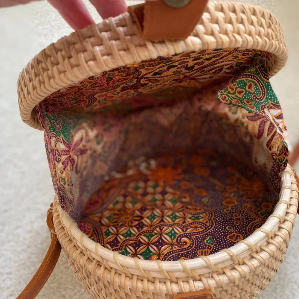 Round solid rattan woven crossbody purse cloth lined, leather accents.